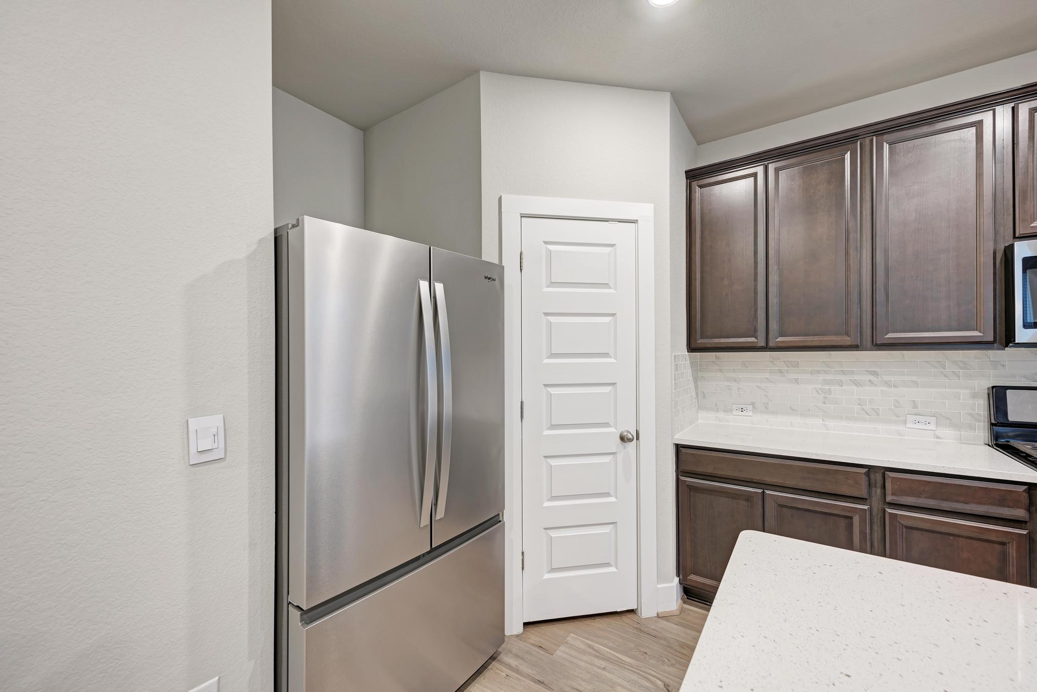 7319 Travertine Spring Drive, Unit 115 Austin, TX 78744 - Photo 22 of 37 a kitchen with stainless steel appliances granite countertop a refrigerator and a sink