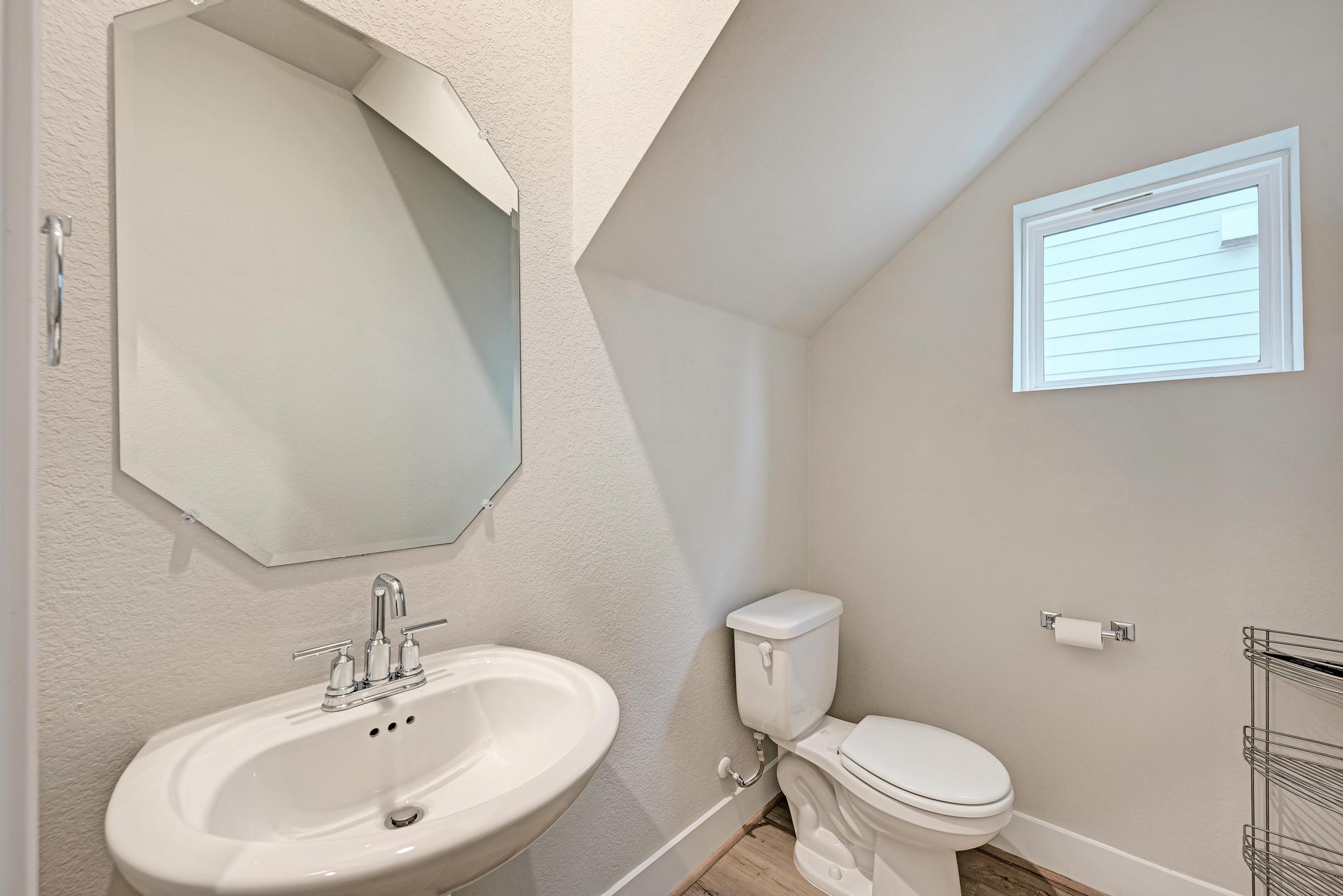 7319 Travertine Spring Drive, Unit 115 Austin, TX 78744 - Photo 23 of 37 a bathroom with a sink a mirror and a toilet