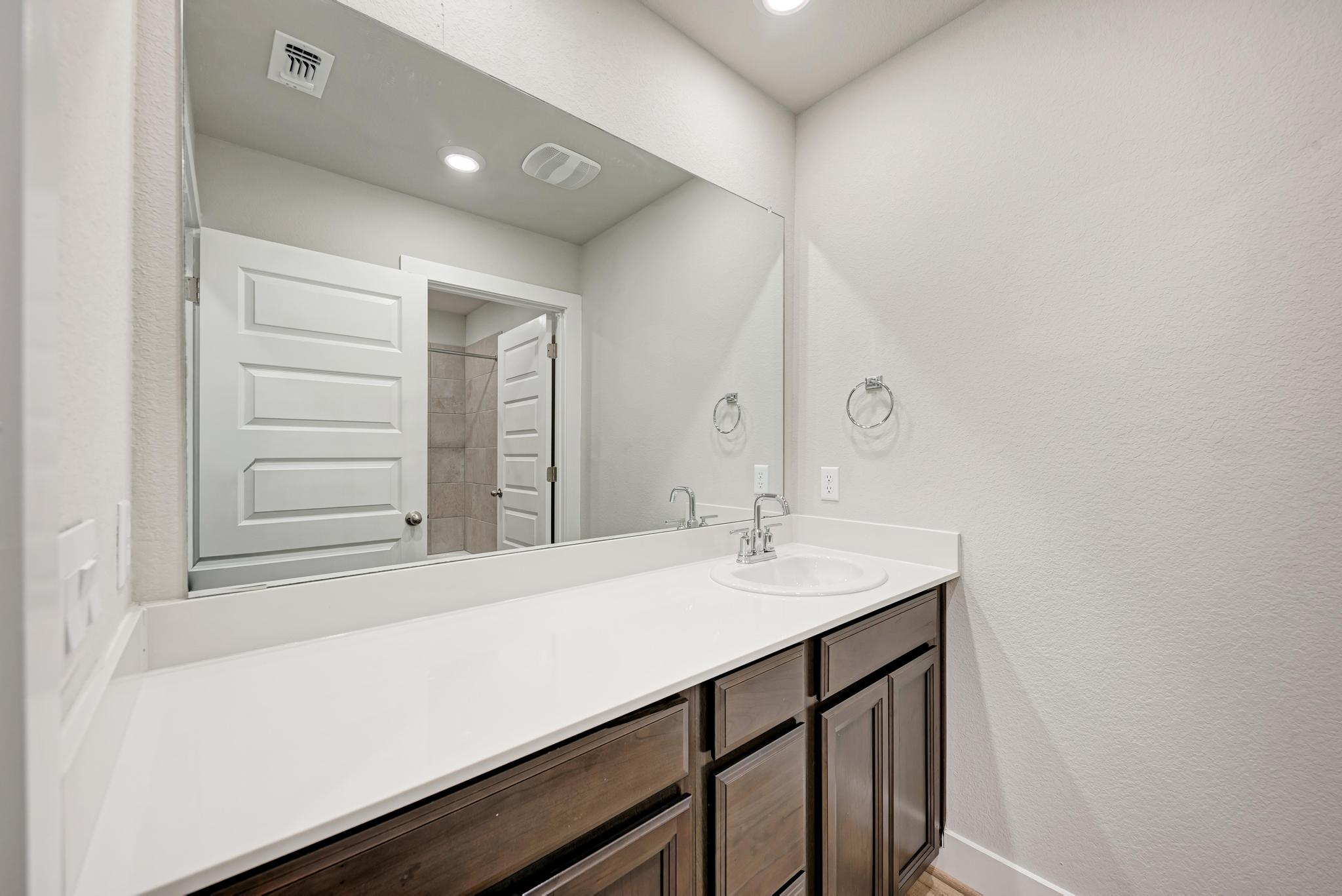 7319 Travertine Spring Drive, Unit 115 Austin, TX 78744 - Photo 29 of 37 a bathroom with a sink and a mirror