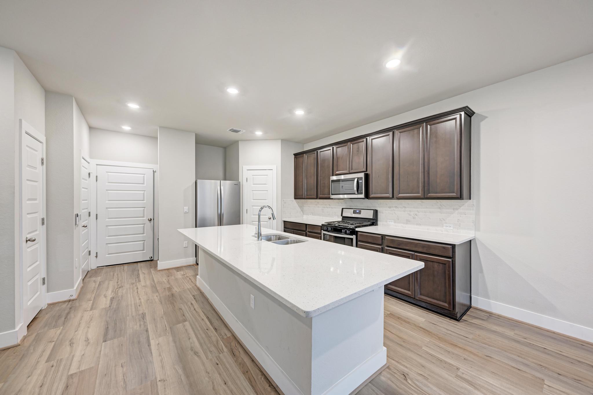 7319 Travertine Spring Drive, Unit 115 Austin, TX 78744 - Photo 3 of 37 a kitchen with a sink a counter top space stainless steel appliances and cabinets
