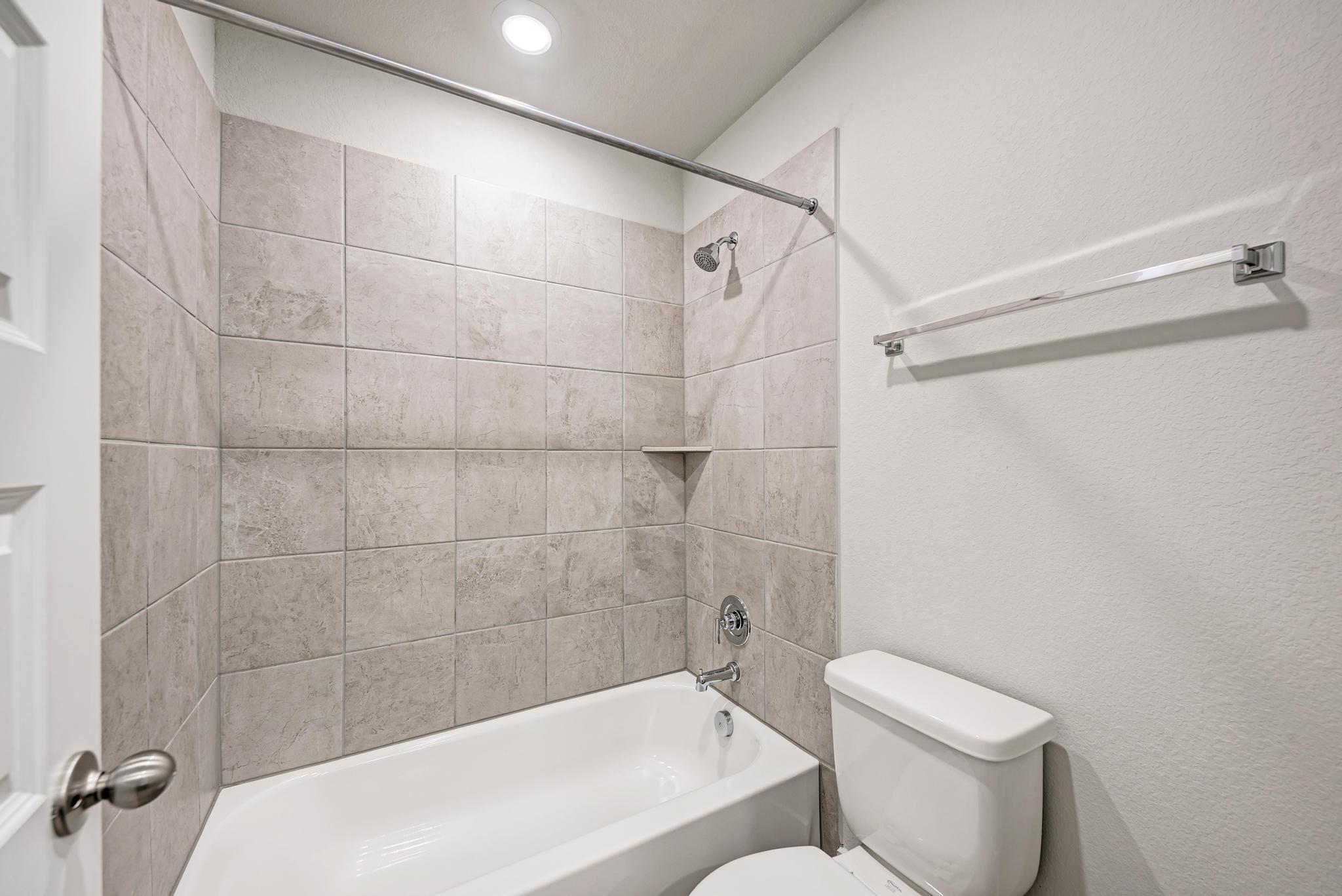 7319 Travertine Spring Drive, Unit 115 Austin, TX 78744 - Photo 30 of 37 a bathroom with a toilet and shower