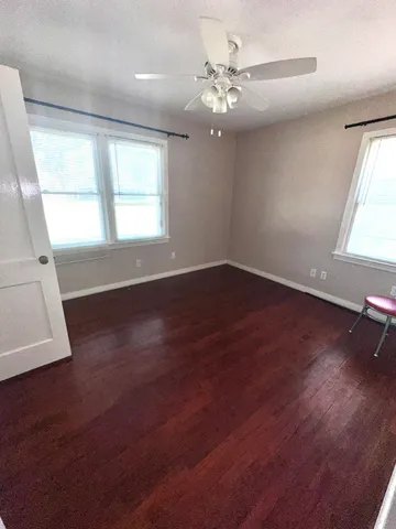 an empty room with wooden floor and window