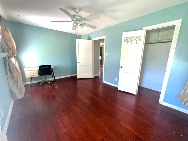 a view of a big room with wooden floor and windows