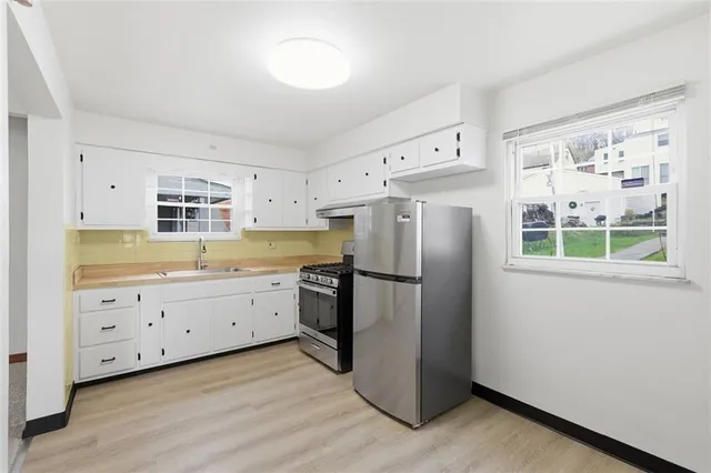 a kitchen with stainless steel appliances a refrigerator and a stove top oven