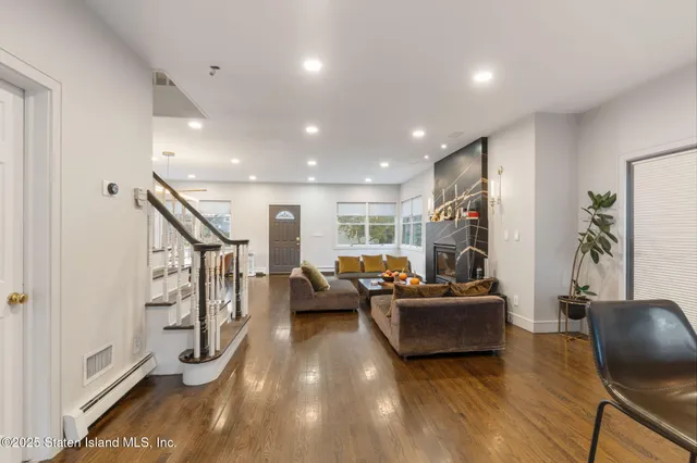 a living room with fireplace furniture and a wooden floor