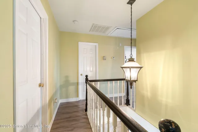 a living room with furniture kitchen view and a wooden floor