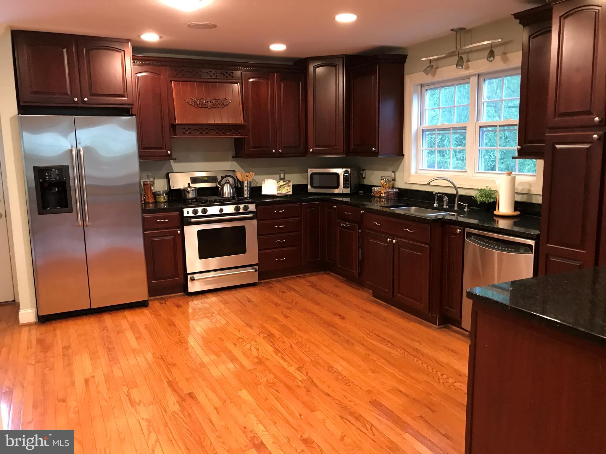 14731 Good Hope Road Silver Spring, MD 20905 - Photo 17 of 30 a kitchen with stainless steel appliances granite countertop a sink a stove a refrigerator cabinets and a counter top space