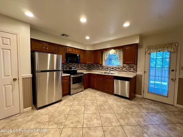 a kitchen with stainless steel appliances granite countertop a refrigerator sink and cabinets