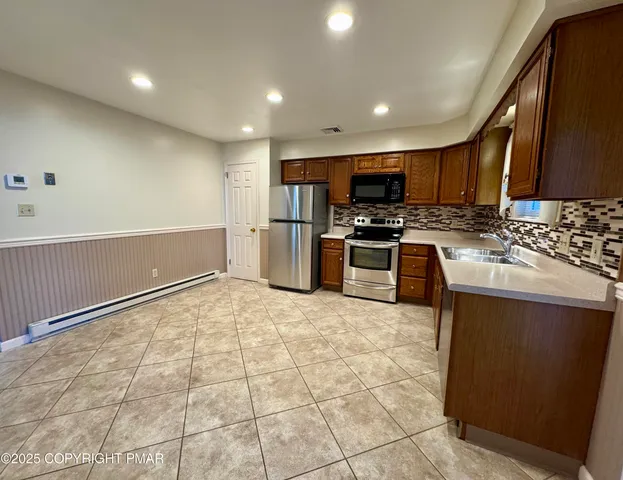 a kitchen with stainless steel appliances granite countertop a stove sink and cabinets