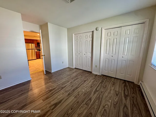 an empty room with wooden floor and entrance
