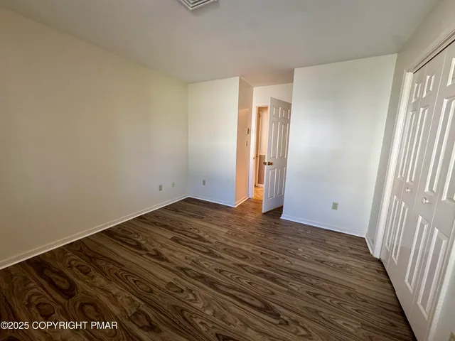 a view of a room with wooden floor and a window