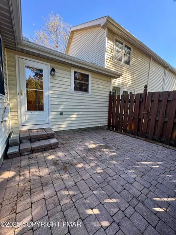 a view of a house with backyard and wooden fence