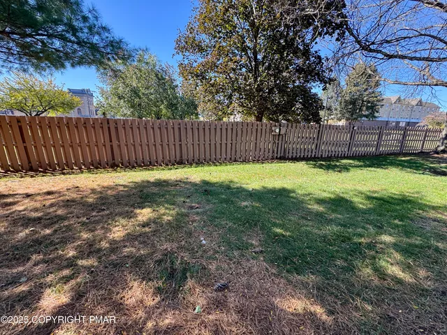 a view of a yard with wooden fence