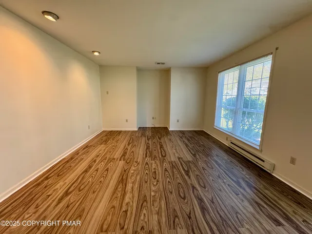 a view of a room with wooden floor and window