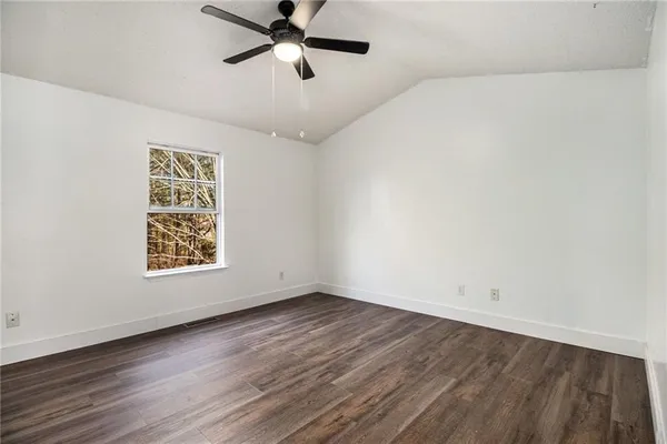 an empty room with a window and a ceiling fan