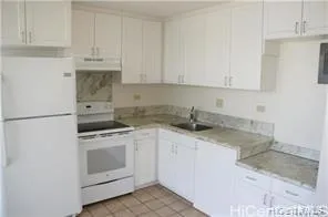 a kitchen with granite countertop white cabinets and white appliances