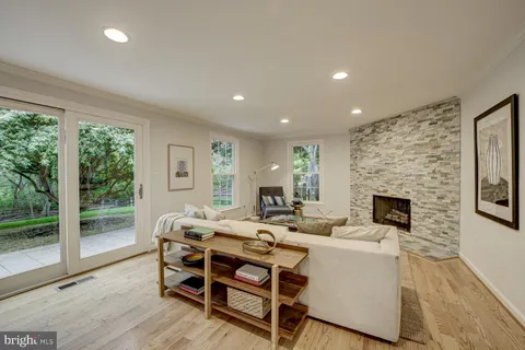 a living room with furniture a fireplace and a floor to ceiling window