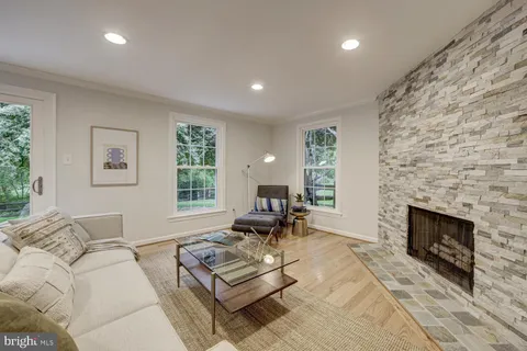 a living room with furniture a fireplace a lamp and a large window