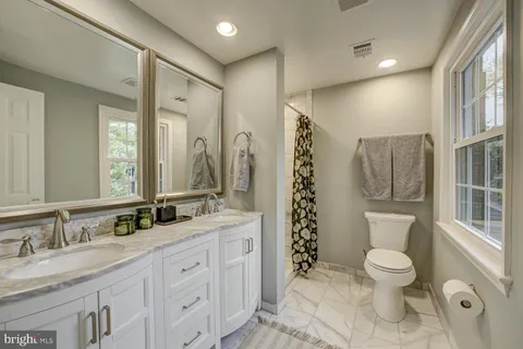 a bathroom with a granite countertop sink toilet and shower