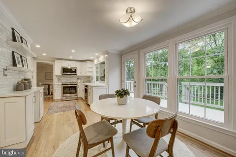 a kitchen with a table chairs microwave and cabinets