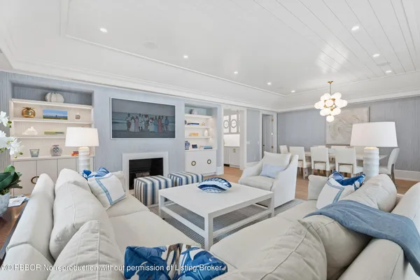 a living room with furniture a fireplace and a chandelier