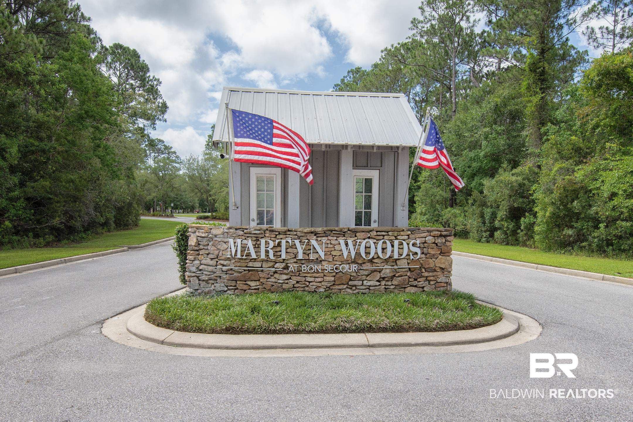18754 Treasure Oaks Road Gulf Shores, AL 36542 - Photo 44 of 53 Stone-clad entry monument featuring a decorative structure with board-and-batten siding and a metal roof