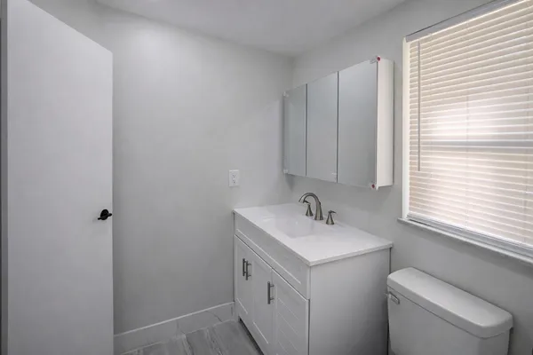 a bathroom with a toilet sink and mirror