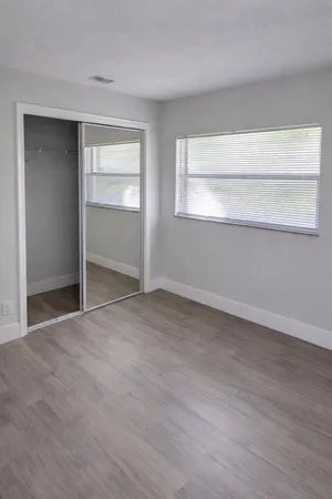 a view of an empty room with closet and a window