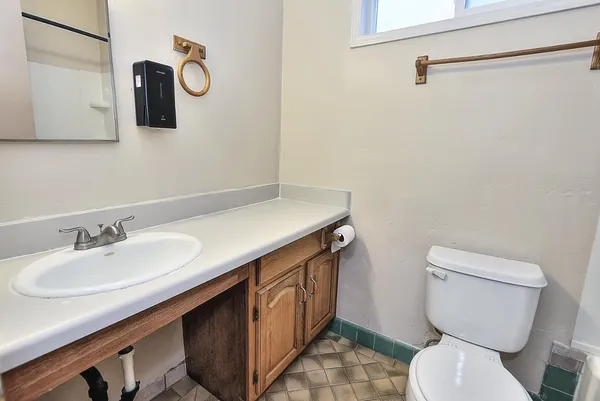 an empty room with wooden floor cabinet and windows