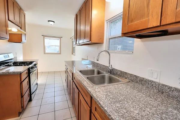a kitchen with stainless steel appliances granite countertop a sink and a stove