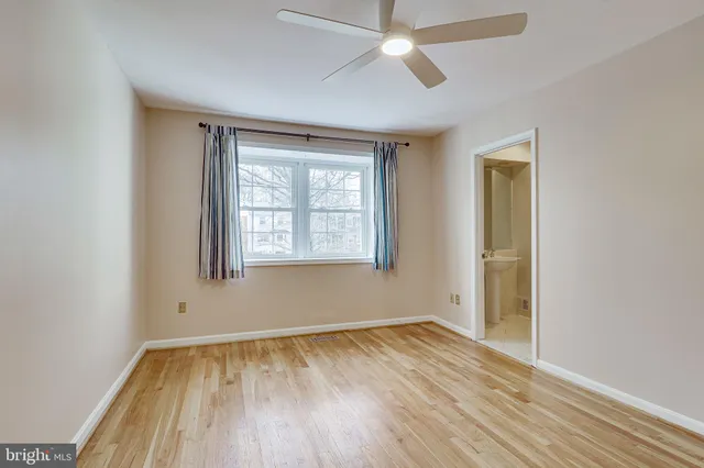 an empty room with a window and wooden floor