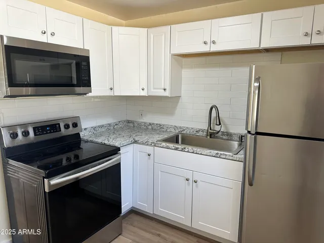 a kitchen with appliances a sink and cabinets