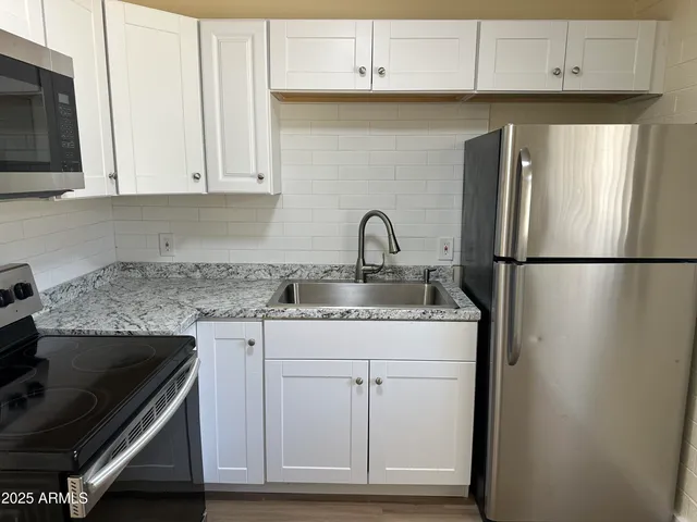 a kitchen with appliances cabinets and a counter top space