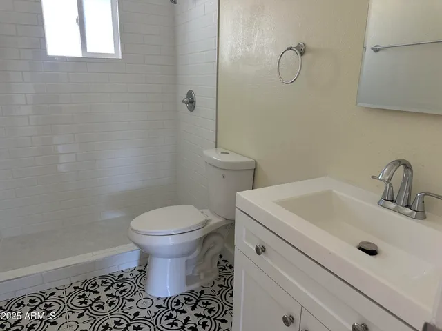 a bathroom with a sink a toilet and a mirror