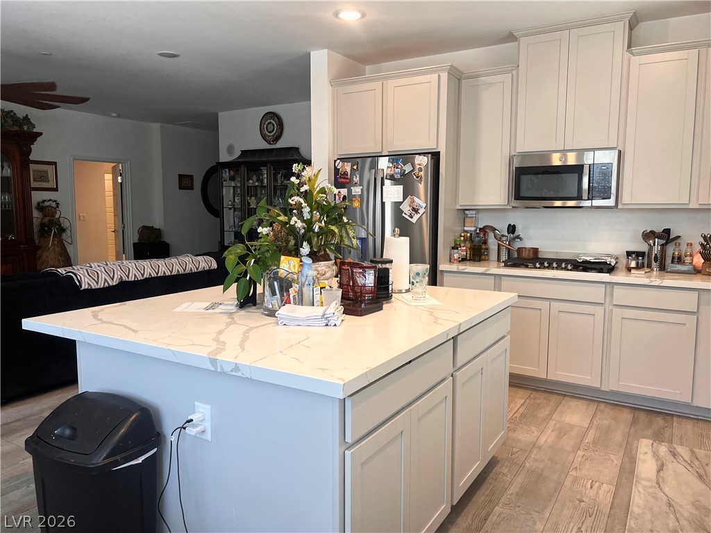 2555 Hampton Road, Unit 2207 Henderson, NV 89052 - Photo 22 of 34 A gourmet kitchen offers a central island, gas range, and built-in microwave, flowing seamlessly into the adjacent living space.
