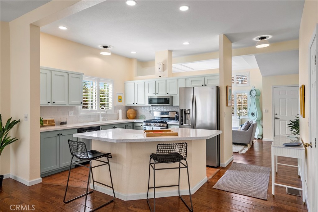 378 Lark Drive Paso Robles, CA 93446 - Photo 4 of 33 a kitchen view with stainless steel appliances a stove a refrigerator a sink dishwasher and a dining table with wooden floor