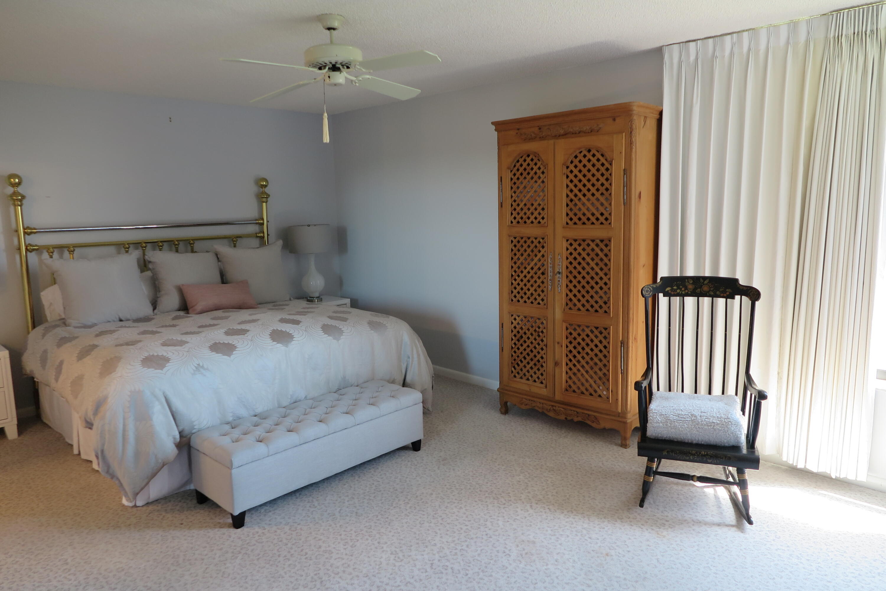 7578 Regency Lake Drive, Unit 501 Boca Raton, FL 33433 - Photo 13 of 32 a bedroom with a bed and a chair