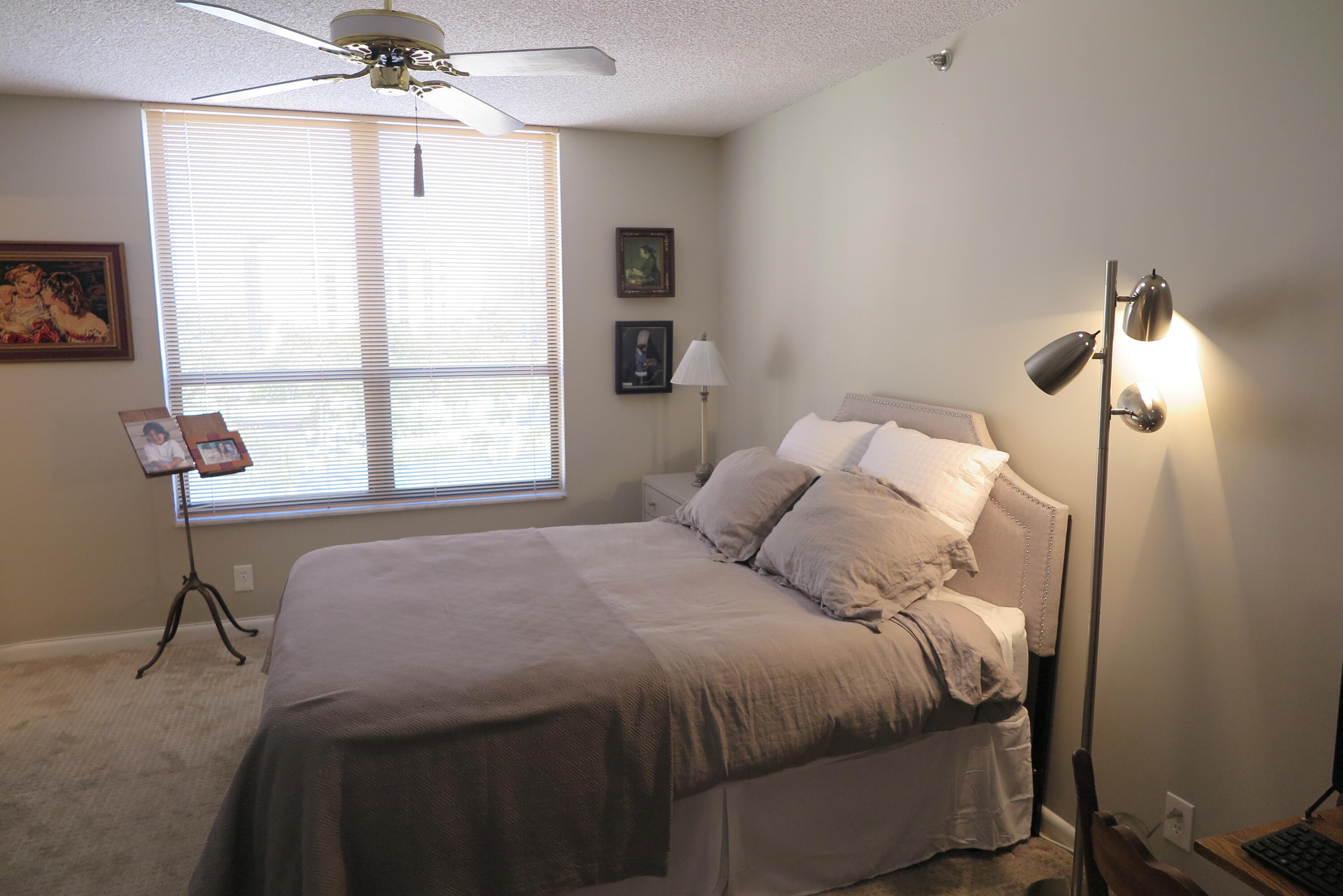 7578 Regency Lake Drive, Unit 501 Boca Raton, FL 33433 - Photo 19 of 32 a bedroom with a bed and a table lamp