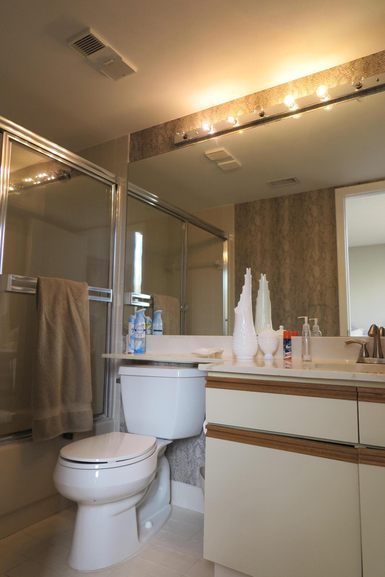 7578 Regency Lake Drive, Unit 501 Boca Raton, FL 33433 - Photo 22 of 32 a bathroom with a toilet a sink and a mirror