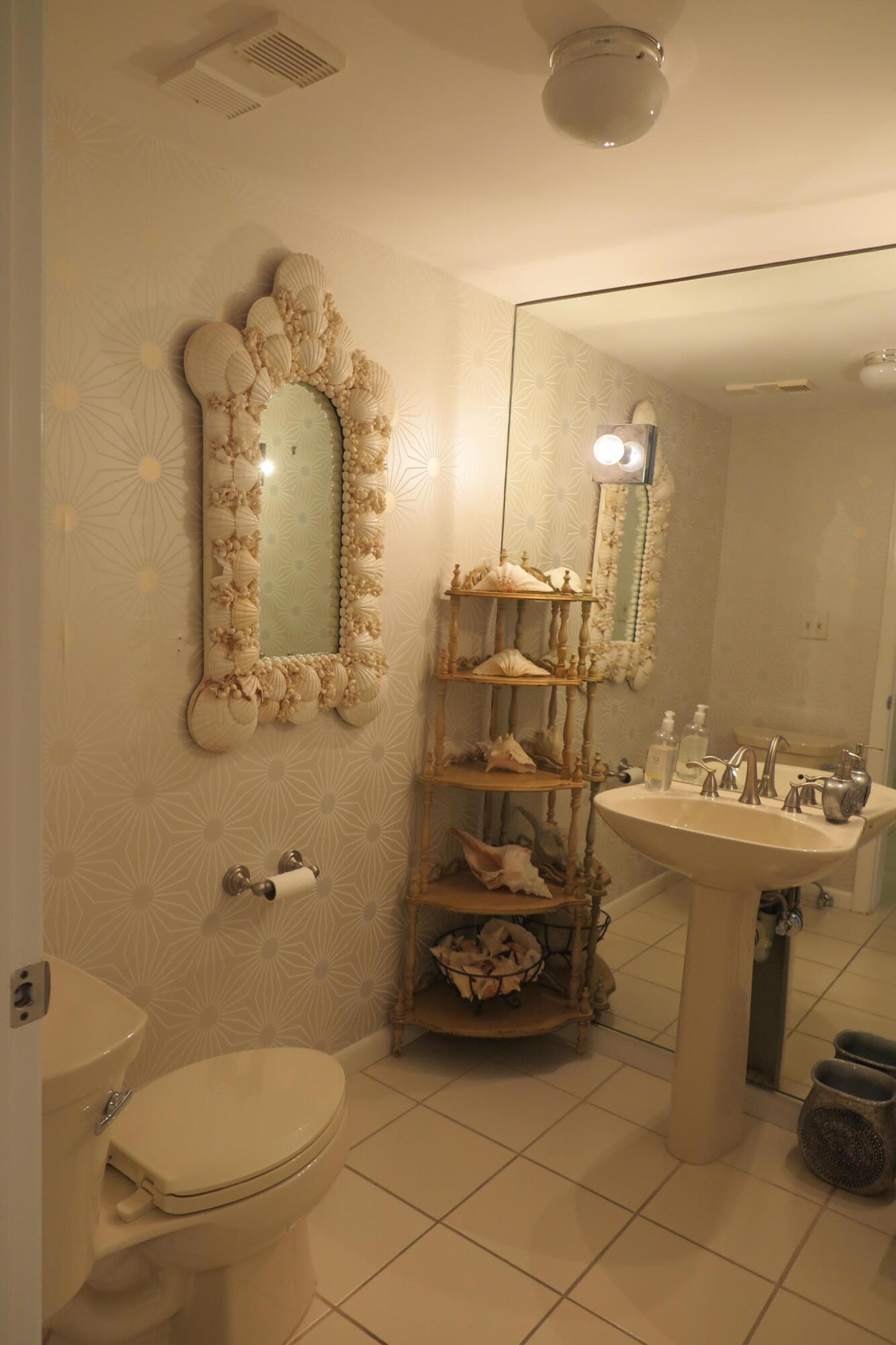 7578 Regency Lake Drive, Unit 501 Boca Raton, FL 33433 - Photo 26 of 32 a bathroom with a sink a toilet and a mirror