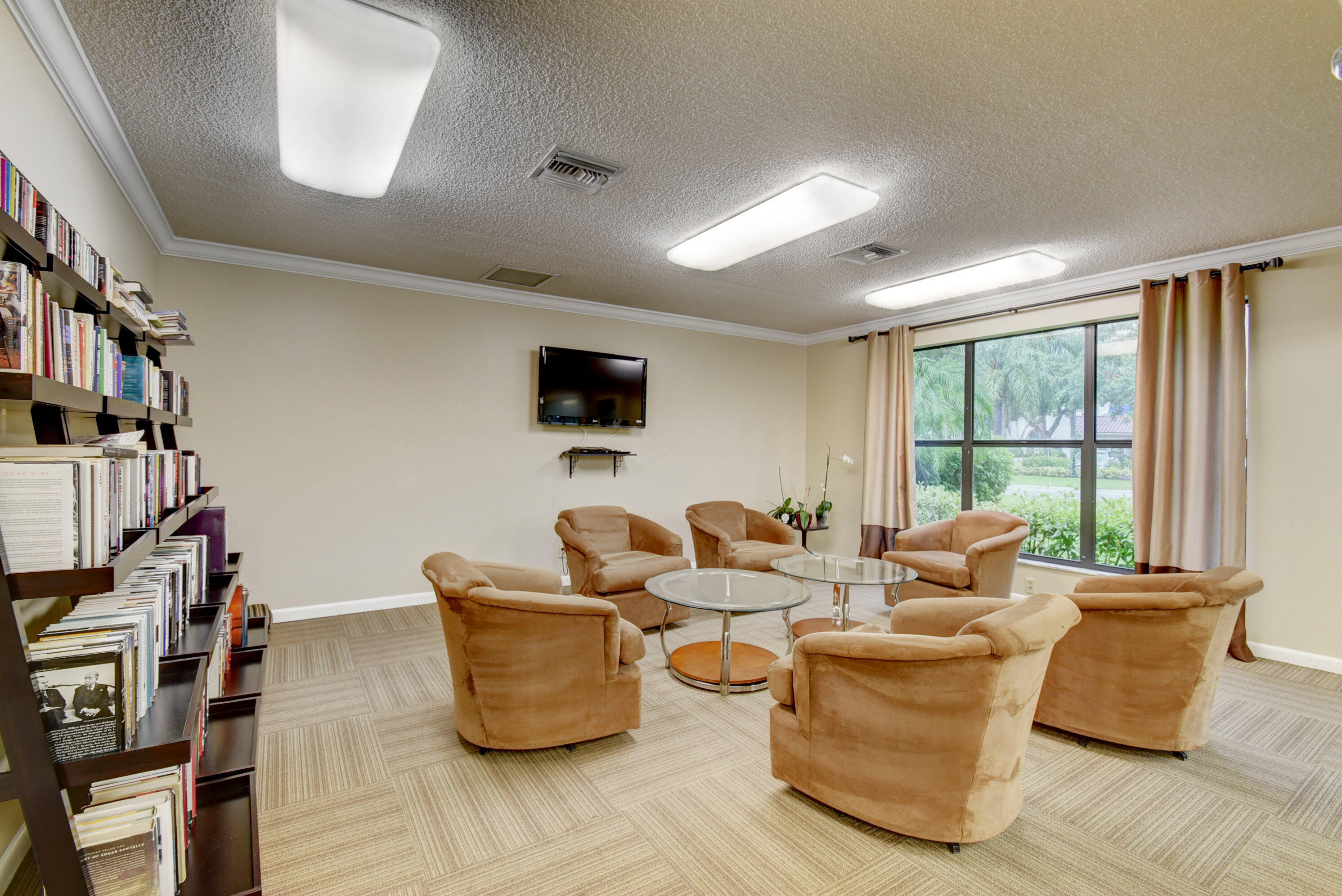 7578 Regency Lake Drive, Unit 501 Boca Raton, FL 33433 - Photo 31 of 32 a living room with furniture and a flat screen tv