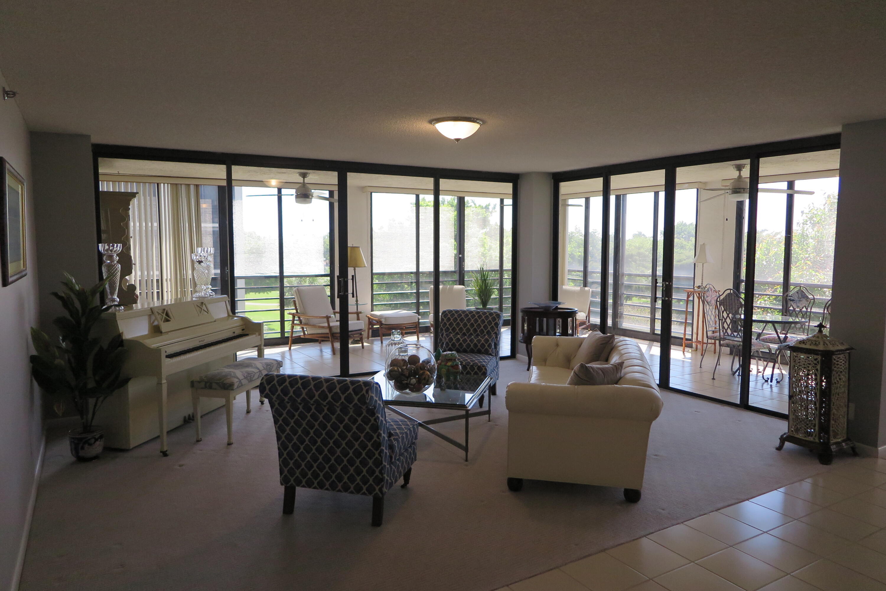 7578 Regency Lake Drive, Unit 501 Boca Raton, FL 33433 - Photo 4 of 32 a living room with furniture and a floor to ceiling window