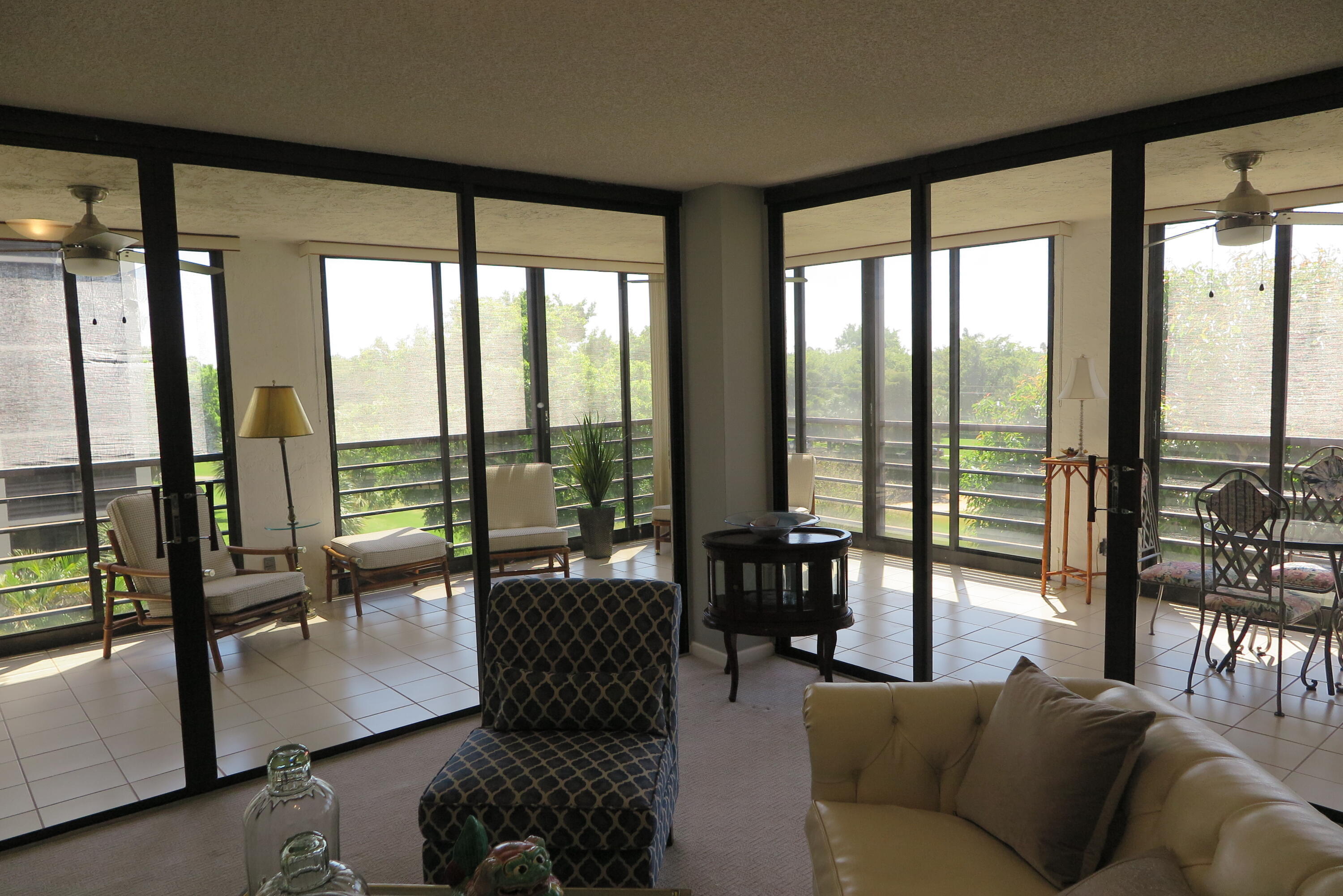 7578 Regency Lake Drive, Unit 501 Boca Raton, FL 33433 - Photo 5 of 32 a living room with furniture and floor to ceiling windows