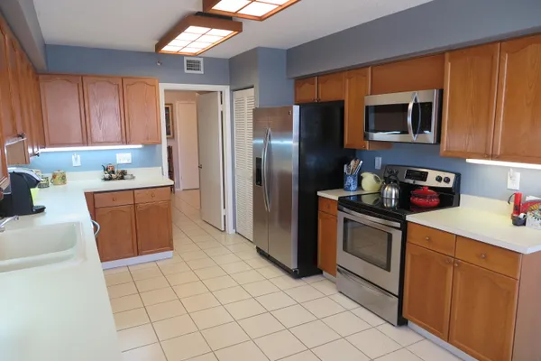 a kitchen with stainless steel appliances granite countertop a refrigerator sink and stove