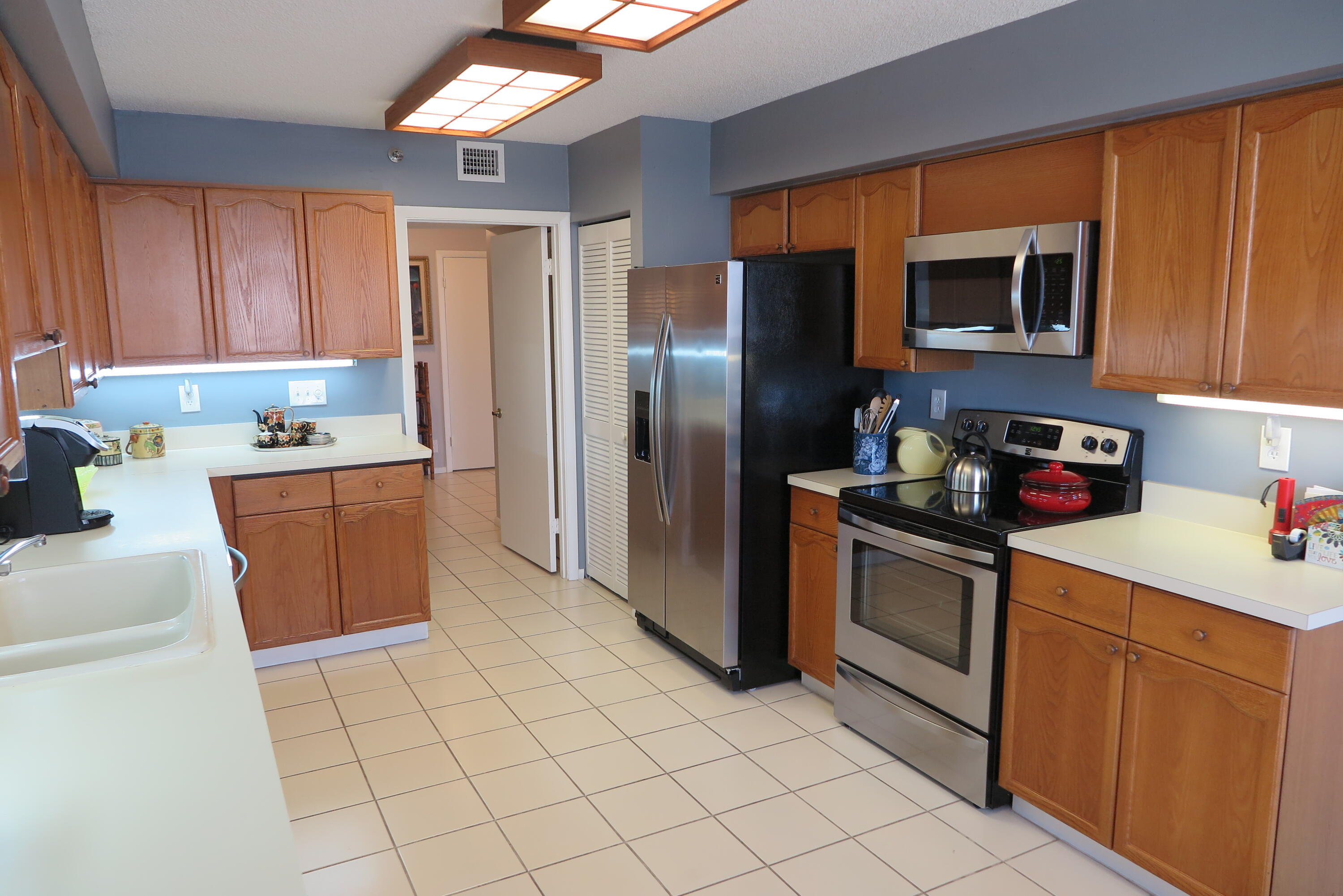 7578 Regency Lake Drive, Unit 501 Boca Raton, FL 33433 - Photo 7 of 32 a kitchen with stainless steel appliances granite countertop a refrigerator sink and stove