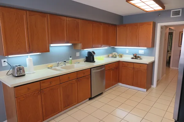 a kitchen with a sink dishwasher stove and cabinets