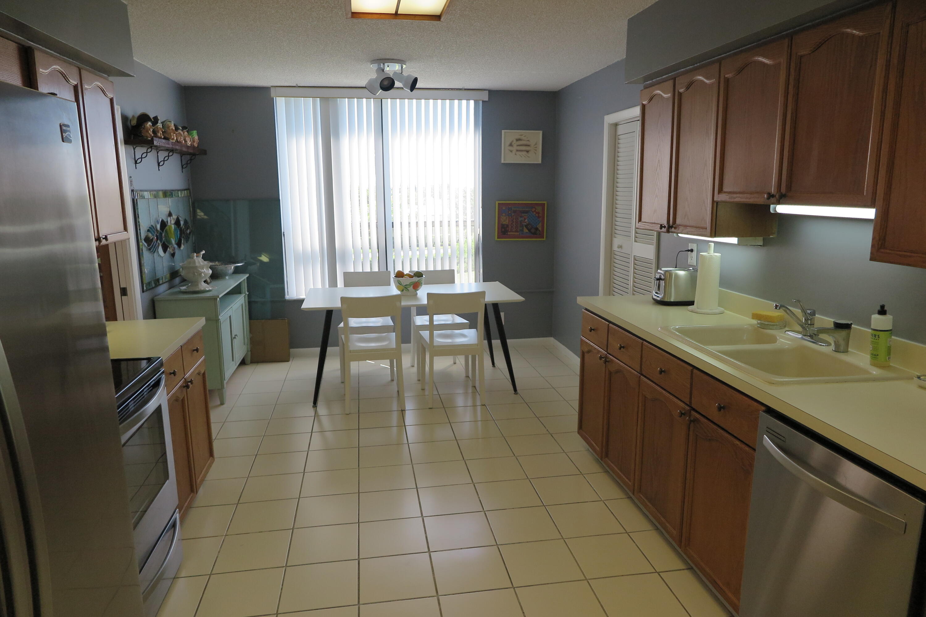 7578 Regency Lake Drive, Unit 501 Boca Raton, FL 33433 - Photo 9 of 32 a kitchen with stainless steel appliances a sink stove and a refrigerator