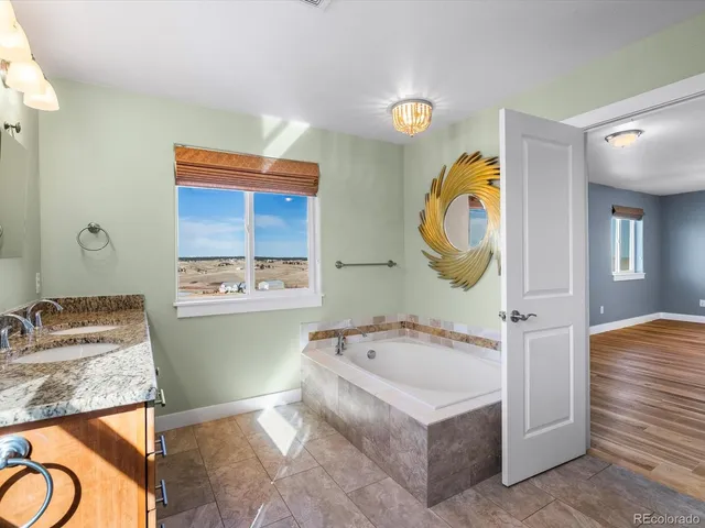 a bathroom with a granite countertop toilet a sink and a mirror