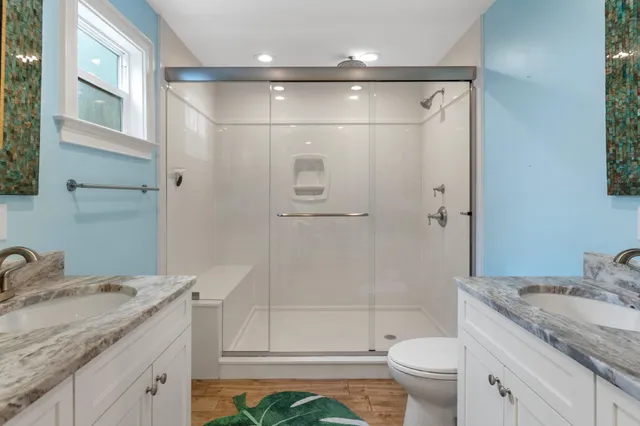 a bathroom with a granite countertop sink toilet and shower