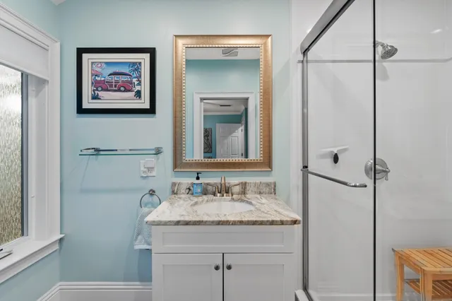 a bathroom with a granite countertop sink and a mirror